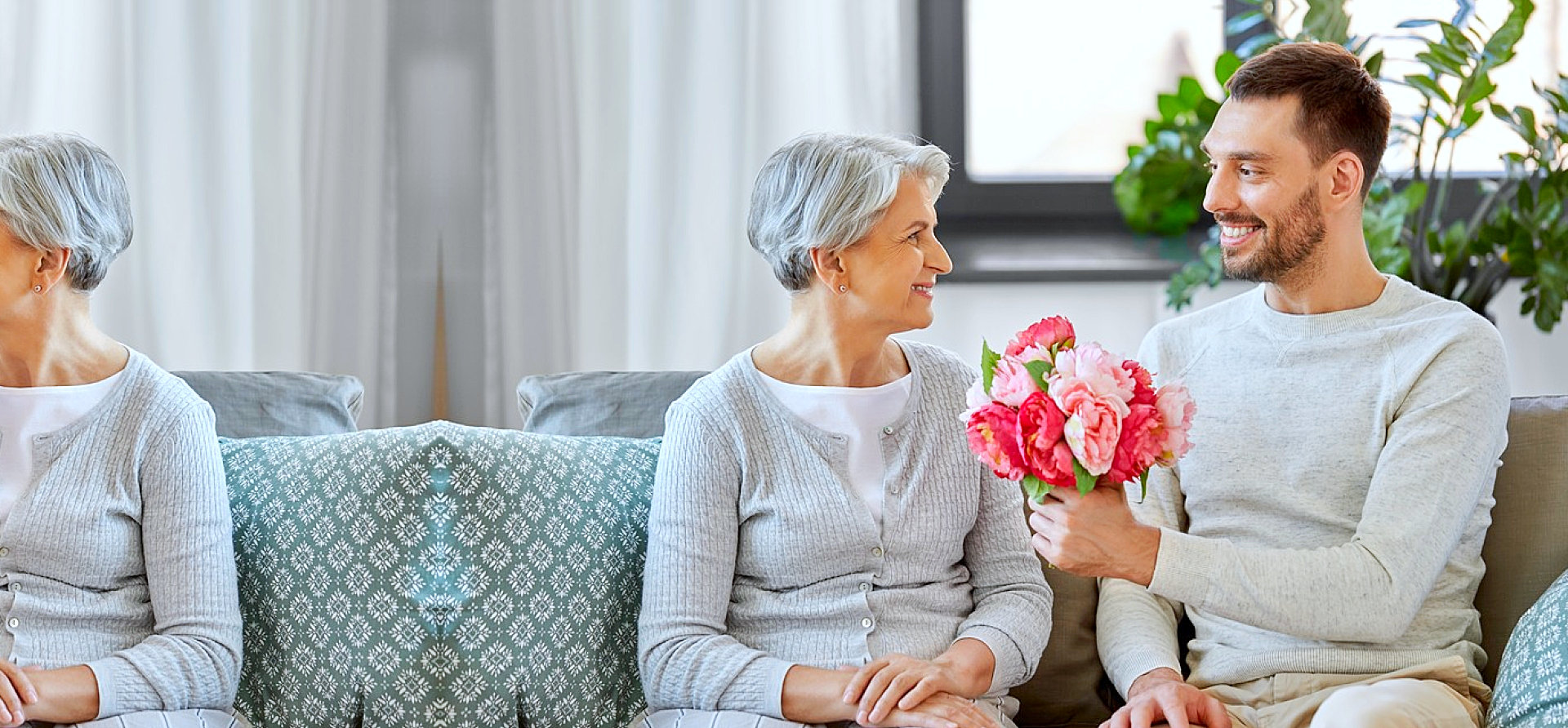 caregiver giving flowers to senior woman