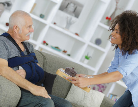 caregiver giving meal to senior man