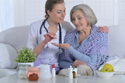 nurse giving senior woman medicine